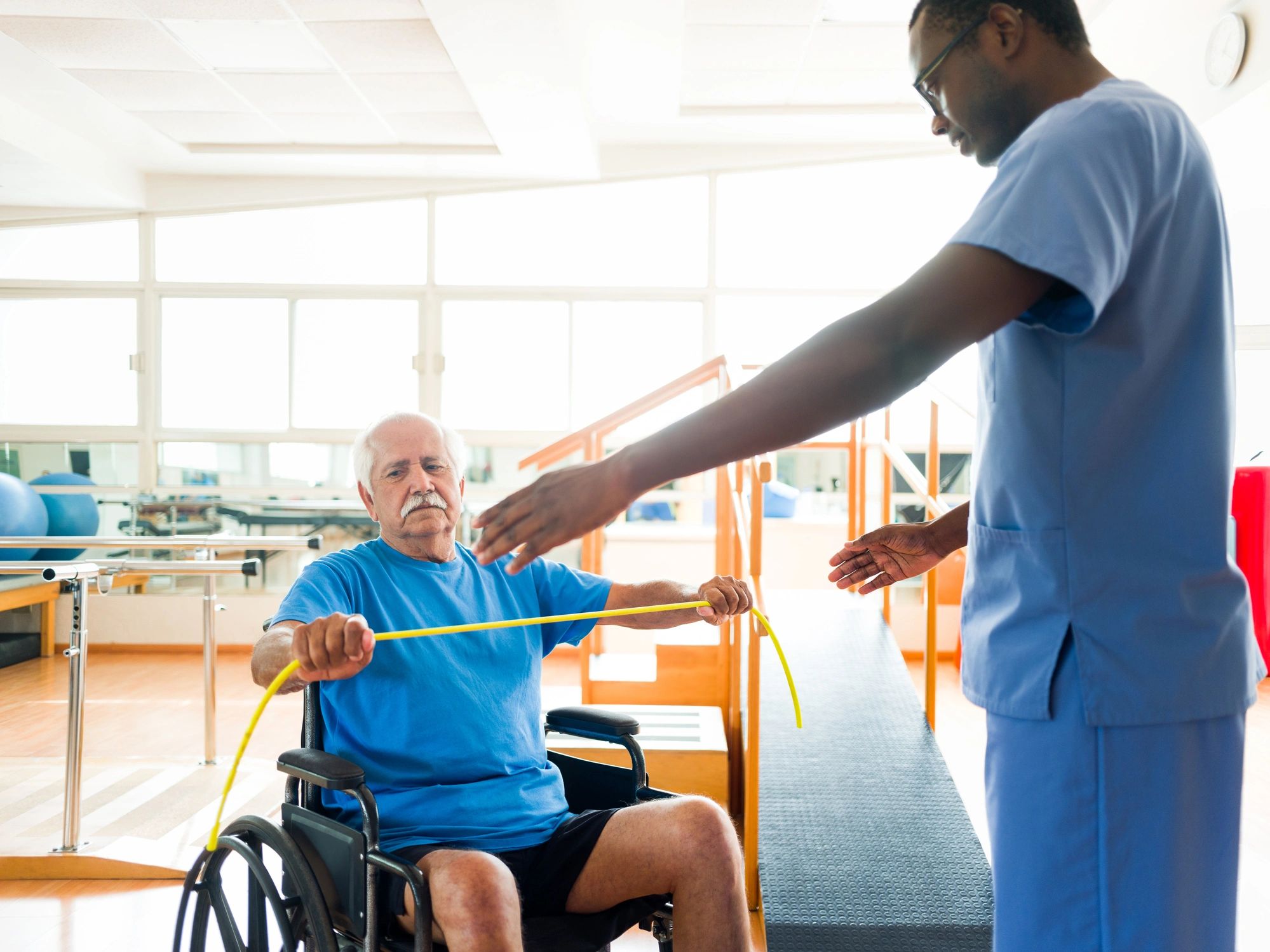 Senior patient doing guided arm exercises during therapy